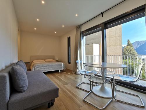 um quarto com um sofá, uma mesa e uma cama em LOFT 18! Cozy loft downtown near the lake with FREE PARKING em Lugano