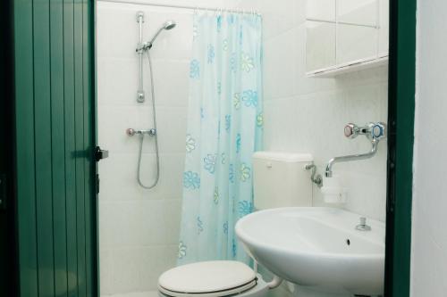 a bathroom with a toilet and a sink and a shower at Pescoluse Houses in Marina di Pescoluse