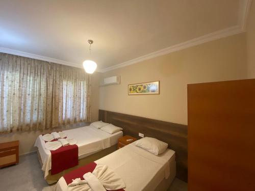 a hotel room with two beds and a window at Dove Apart Hotel in Fethiye