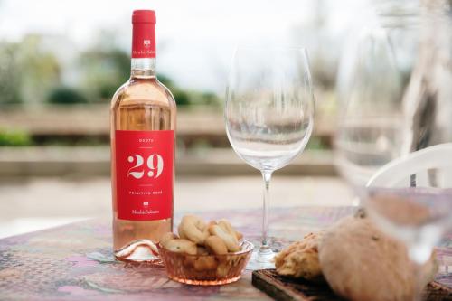a bottle of wine and a glass on a table at Pescoluse Houses in Marina di Pescoluse