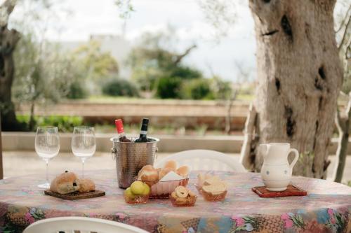 a table with wine glasses and food on it at Pescoluse Houses in Marina di Pescoluse