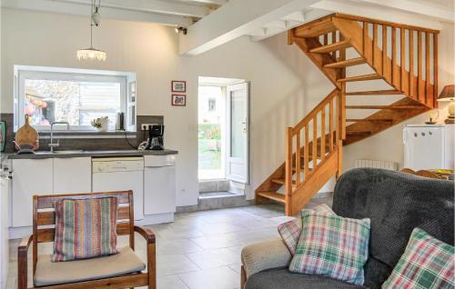 a living room with a kitchen and a staircase at La Petite Mainnerie in Jobourg