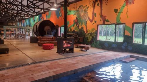 a living room with a swimming pool and a fireplace at Momora distrito selva in Santa Ana