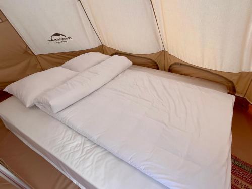 a bed in a tent with two pillows on it at S Plus Bungalow in Sa Pa