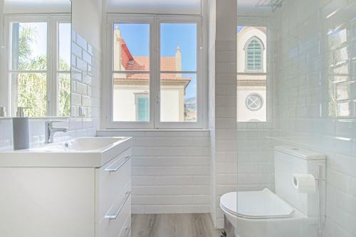 een witte badkamer met een toilet en een wastafel bij Pi Houses in Funchal