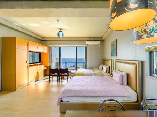 a bedroom with a bed and a view of the ocean at OROJEJU in Seogwipo