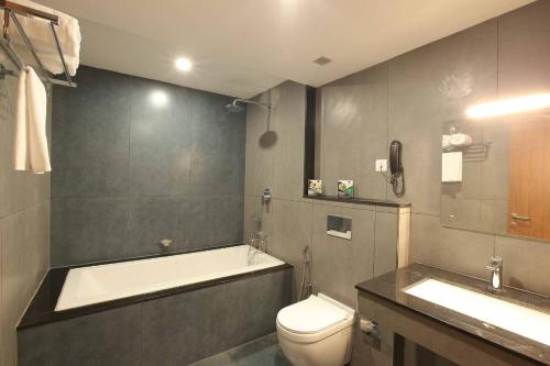 a bathroom with a tub and a toilet and a sink at CHALLYIL CASTLE in Mararikulam