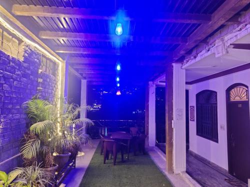 a patio with a table and chairs and purple lights at Shri Ganga View Guest House in Rishīkesh