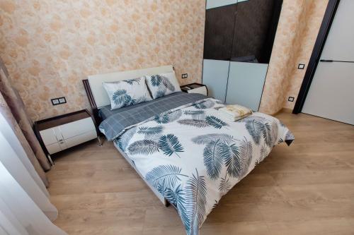 um quarto com uma cama com um edredão azul e branco em Красива та затишна, дуже тепла квартира з підігрівом підлоги em Dnipro
