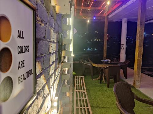 a room with a brick wall with a table and chairs at Shri Ganga View Guest House in Rishīkesh