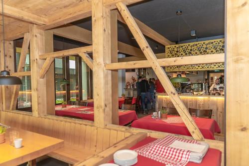 a dining room with wooden walls and red tables at Frutt Living in Kerns