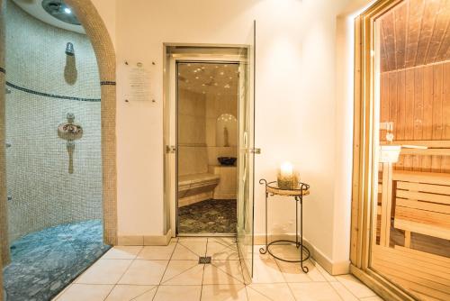 a bathroom with a shower and a glass door at Lodenwirt Residence in Vandoies