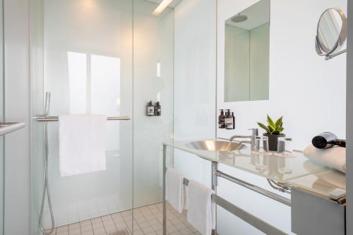 a bathroom with a glass shower and a sink at INNSiDE by Meliá München Parkstadt Schwabing in Munich