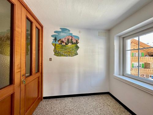 a room with a window and a painting on the wall at Central Apartment Canazei in Canazei