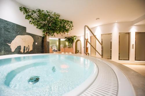 a jacuzzi tub in a house with a elephant mural at Lodenwirt Residence in Vandoies