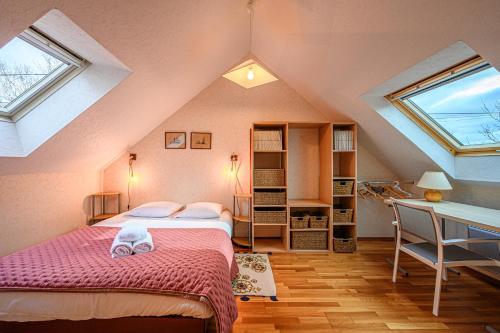 een slaapkamer op zolder met 2 bedden en een bureau bij Kercolo - Maison de campagne à 10min des plages in Surzur