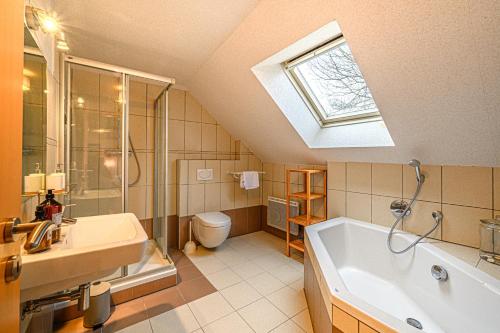 baño con lavabo, bañera y ventana en Kercolo - Maison de campagne à 10min des plages, en Surzur