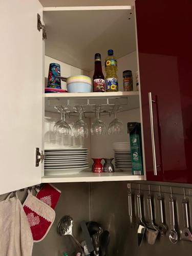 a kitchen cabinet filled with dishes and glasses at Villa Blanche appartement 2 in Le Mont-Dore