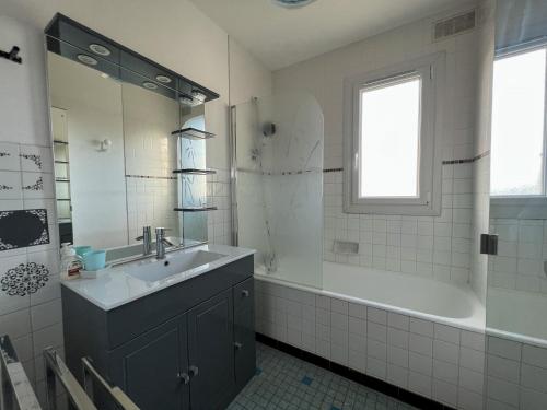 baño con lavabo, bañera y ventana en L'escapade - Maison familiale avec jardin Vannes, en Vannes