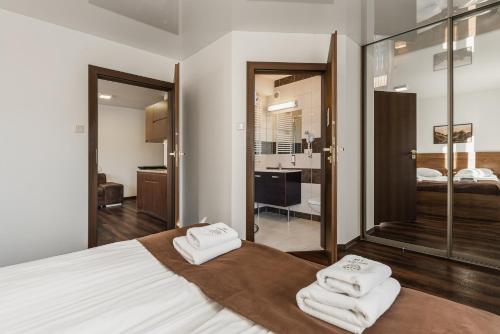 a bedroom with a bed with two towels on it at Apartamenty Eko in Szczawnica