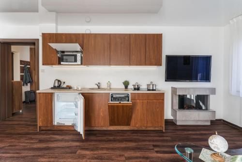 an open kitchen with wooden cabinets and a microwave at Apartamenty Eko in Szczawnica
