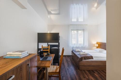 a bedroom with a bed and a desk with a laptop at Apartamenty Eko in Szczawnica