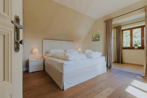 ein Schlafzimmer mit einem großen weißen Bett und einem Fenster in der Unterkunft Hof Niglberg Südsteiermark in Sankt Johann im Saggautal