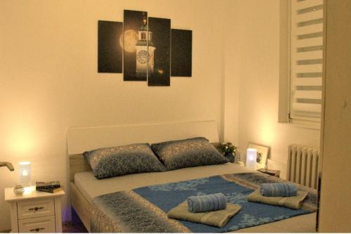 a bedroom with a bed with two pillows on it at Novi Sad Apartman Tenigo in Novi Sad