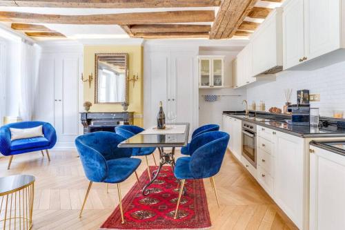 une cuisine avec des chaises bleues et une table dans l'établissement Suite Montorgueil - Hyper Centre Paris - Chatelet 3min, à Paris