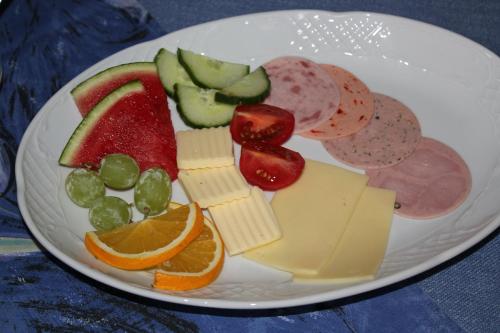 a plate of food with cheese and fruit on it at Landgasthof Weberhans in Harburg