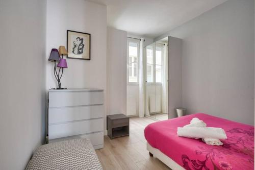 - une chambre avec un lit rose et une commode dans l'établissement Bel appartement avec lit double dans Paris 15ème, à Paris