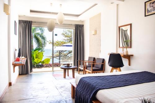 a hotel room with a bed and a view of the ocean at Saravoan-Kep Hotel in Kep