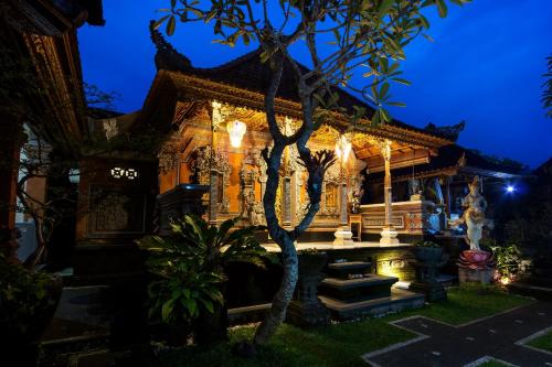 a building with a tree in front of it at night at The Tunjung Ubud Retreat in Ubud