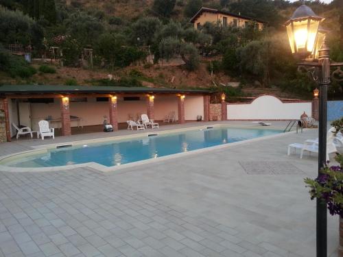 a swimming pool with a light pole next to a house at L'Uliveto in Reitano
