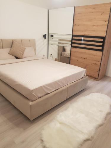 een slaapkamer met een bed, een spiegel en een tapijt bij City Diamond Apartment in Skopje