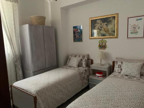 1 Schlafzimmer mit 2 Einzelbetten und einem Kühlschrank in der Unterkunft Il Trullo di Nonno Angelo San Marco in Locorotondo