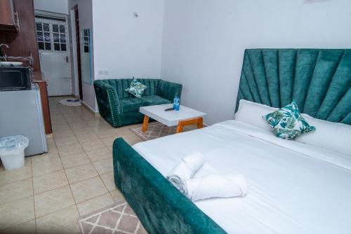 um quarto com uma cama, um sofá e uma mesa em The Green Apartment em Ruaka