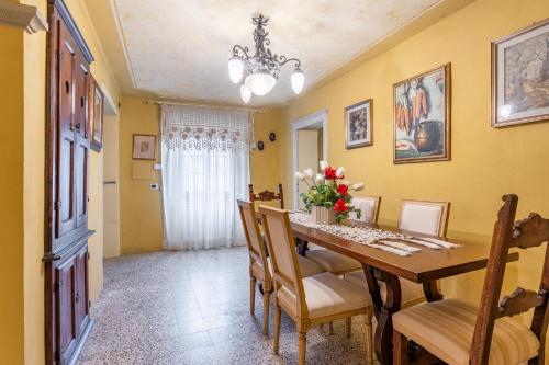 a dining room with a wooden table and chairs at Grillo Rosso 5 in Molazzana