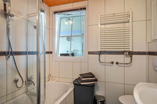 een badkamer met een bad, een wastafel en een toilet bij Chilli Home in Tettnang