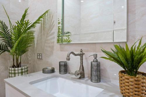 a bathroom with a sink and two potted plants at Unique and secluded cosy cottage in Bilpin