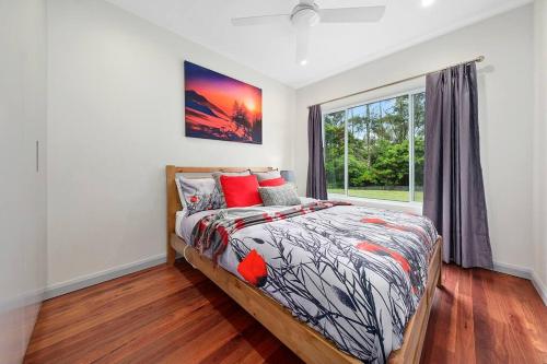a bedroom with a bed and a window at Unique and secluded Poppy Cottage in Bilpin
