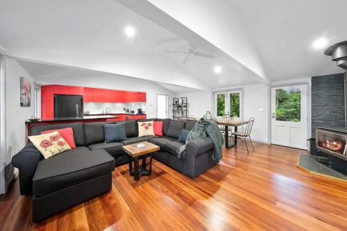 a living room with a couch and a fireplace at Unique and secluded Poppy Cottage in Bilpin