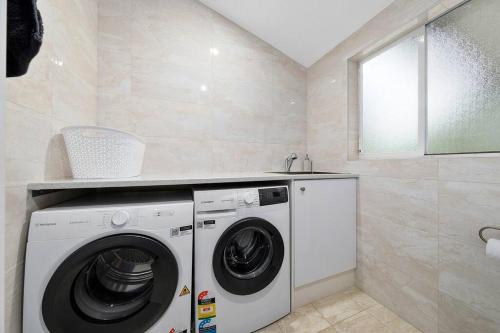 a laundry room with a washing machine and a sink at Unique and secluded Poppy Cottage in Bilpin