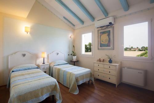 a bedroom with two beds and two windows at COUNTRY HOUSE CASAMIRIAM in Mirano