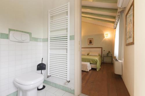 a bathroom with a toilet and a bed at COUNTRY HOUSE CASAMIRIAM in Mirano