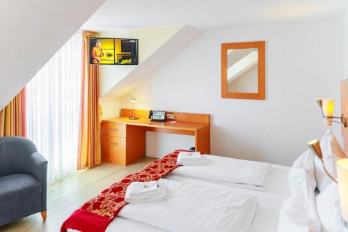 a hotel room with a bed and a desk at Bodensee-Hotel Kreuz in Uhldingen-Mühlhofen