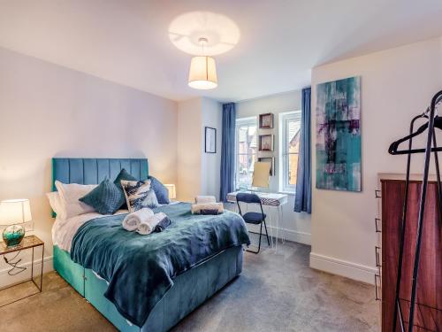 a bedroom with a blue bed and a desk at Number Fifty-Eight in Belper