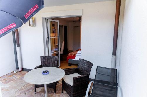 a small patio with a table and chairs and a bedroom at Bodensee-Hotel Kreuz in Uhldingen-Mühlhofen