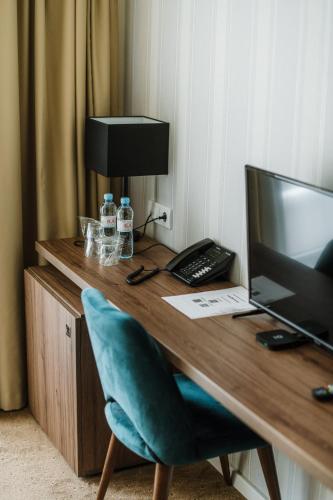 a wooden desk with a computer and a chair at Hotel Nais in Niš