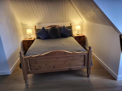 a bedroom with a wooden bed with two lamps at Seasidesteps in Fishguard